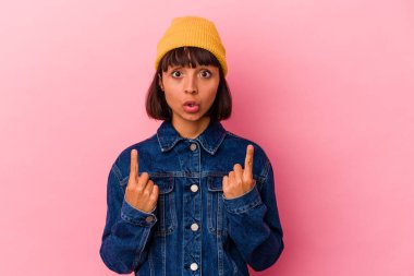 Pembe arka planda izole edilmiş, ağzı açık, üst tarafı gösteren genç melez bir kadın..