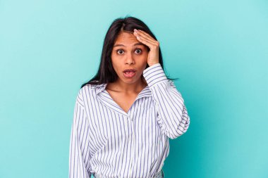 Mavi arka planda soyutlanmış genç Latin bir kadın şok geçiriyordu. Önemli bir buluşmayı hatırladı..