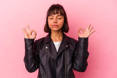 Pembe arka planda soyutlanmış genç melez kadın yoğun bir günün ardından rahatlıyor, yoga yapıyor..