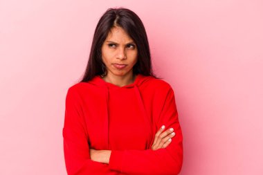 Pembe arka planda izole edilmiş genç Latin kadın tekrarlanan bir görevden yoruldu..