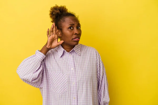 Mladá Africká Americká Žena Izolované Žlutém Pozadí Snaží Poslouchat Klepy — Stock fotografie
