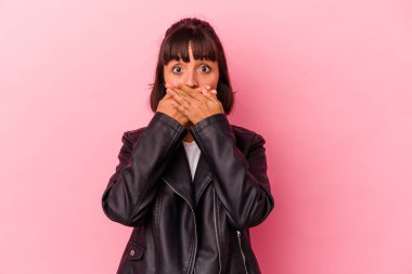 Pembe arka planda izole edilmiş genç melez kadın elleri endişeli bir şekilde ağzı örtüyor..