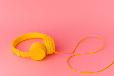 Sarı kulaklıklar pembe arka planda izole edilmiş.