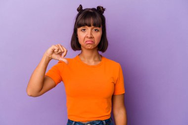 Mor arka planda izole edilmiş genç melez bir kadın. Hoşnutsuz bir jest gösteriyor. Anlaşmazlık konsepti.