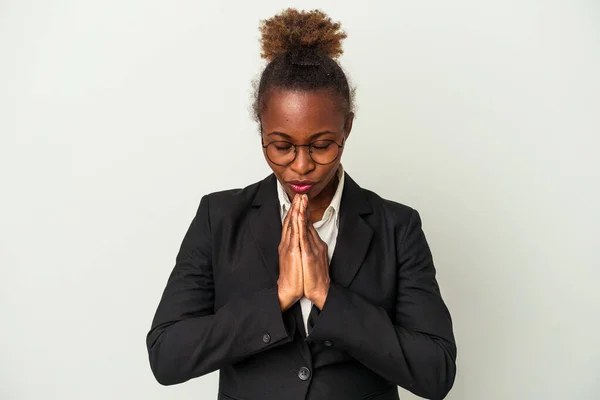 Young business african american woman isolated on white background holding hands in pray near mouth, feels confident.