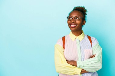 Genç Afrikalı Amerikalı kadın izole edilmiş geçmişinde kollarını kavuşturarak gülümsüyor..
