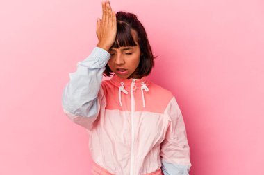 Pembe arka planda izole edilmiş genç bir ırk kadını bir şeyi unutuyor. Alnına avuç içi ve gözlerini kapayarak vuruyor..