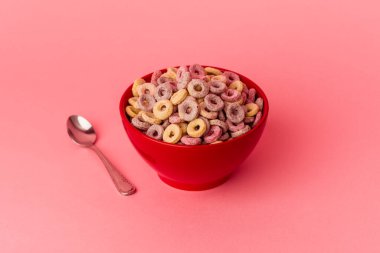 Mısır gevreği kasesi pembe arka planda izole edilmiş.