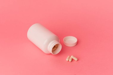 Pembe arka planda izole edilmiş haplar