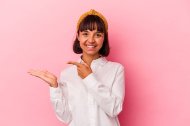 Pembe arka planda izole edilmiş genç melez bir kadın..