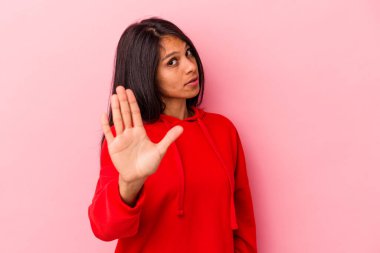 Pembe arka planda izole edilmiş genç Latin kadın iğrenme belirtisi gösteren birini reddediyor..