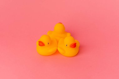 Pembe arka planda izole edilmiş plastik ördekler.