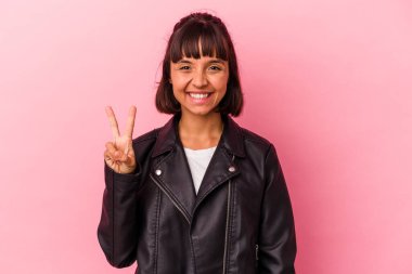Pembe arka planda izole edilmiş genç melez kadın iki numarayı parmaklarıyla gösteriyor..