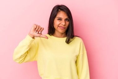 Pembe arka planda izole edilmiş genç Latin kadın baş parmağını aşağı gösteriyor, hayal kırıklığı konsepti..