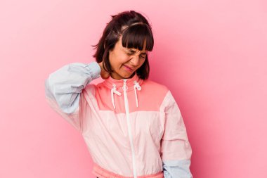 Genç melez kadın pembe arka planda izole edilmiş. Oturaklı yaşam tarzı nedeniyle boyun ağrısı çekiyor..