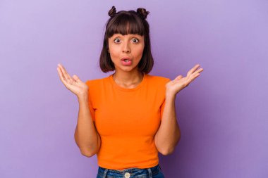 Mor arka planda izole edilmiş genç melez kadın şaşırmış ve şok olmuş..