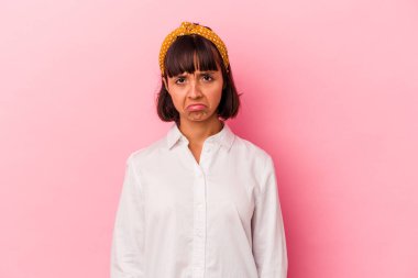 Genç melez kadın pembe arka planda izole edilmiş üzgün, ciddi yüzlü, mutsuz ve hoşnutsuz..