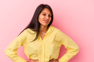 Pembe arka planda izole edilmiş genç Latin kadın üzgün, ciddi yüz, mutsuz ve hoşnutsuz hissediyor.