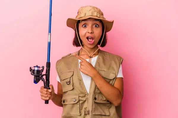 Young Mixed Race Fisherwoman Holding Rod Isolated Pink Background Pointing — Stock Photo, Image