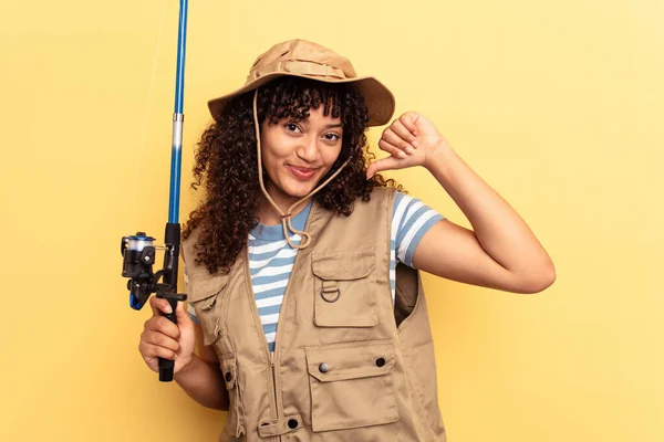 Young Mixed Race Fisherwoman Holding Rod Isolated Yellow Background Feels — Stock Photo, Image
