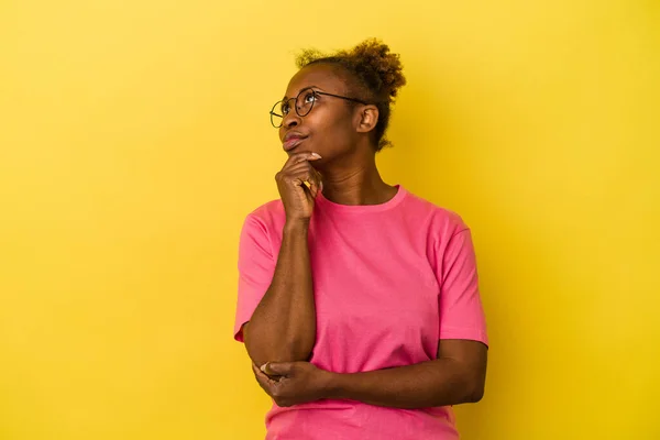 Mujer Afroamericana Joven Aislada Sobre Fondo Amarillo Pensando Mirando Hacia —  Fotos de Stock