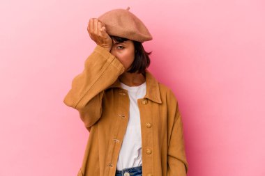 Pembe arka planda izole edilmiş genç bir ırk kadını bir şeyi unutuyor. Alnına avuç içi ve gözlerini kapayarak vuruyor..