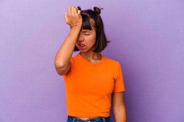 Mor arka planda izole edilmiş genç bir ırk kadını bir şeyi unutuyor, alnına avuç içi ile vuruyor ve gözlerini kapıyor..