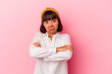 Pembe arka planda soyutlanmış genç bir ırk kadını omuzlarını silker ve gözleri açık kalır..