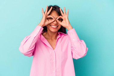 Mavi arka planda izole edilmiş genç Latin bir kadın heyecanlı..