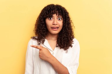 Sarı arka planda izole edilmiş genç, melez bir kadın.