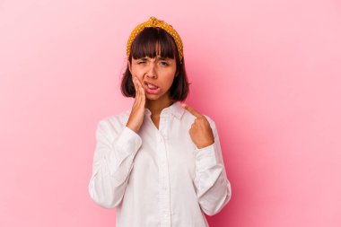 Genç melez kadın pembe arka planda izole edilmiş güçlü bir diş ağrısı, azıdişi ağrısı var..