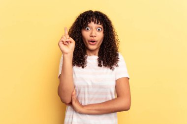 Sarı arka planda soyutlanmış genç melez bir kadının harika bir fikri var, yaratıcılık kavramı..