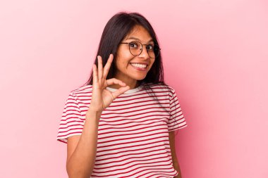 Pembe arka planda izole edilmiş genç Latin kadın neşeli ve kendinden emin, iyi bir hareket gösteriyor..