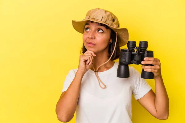 Junge Mischlingsforscherin Mit Fernglas Auf Gelbem Hintergrund Die Mit Zweifelndem — Stockfoto