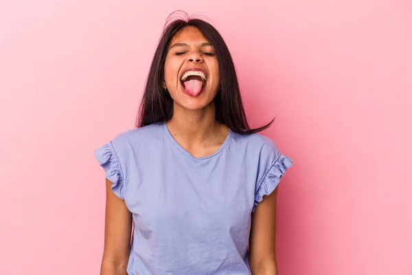 若いですラテン女性絶縁上のピンクの背景面白いとフレンドリーなステッキングアウト舌 — ストック写真