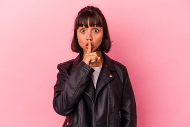 Pembe arka planda soyutlanmış genç melez bir kadın ya sır saklıyor ya da sessizlik istiyor..