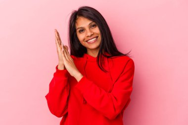 Pembe arka planda izole edilmiş genç Latin kadın enerjik ve rahat hissediyor, ellerini ovuşturuyor..