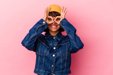 Pembe arka planda soyutlanmış genç melez bir kadın heyecanlı..