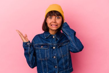 Pembe arka planda izole edilmiş genç melez kadın öfkeyle bağırıyor..