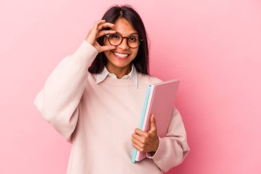 Pembe arka planda izole edilmiş genç Latin bir bayan heyecanlı..