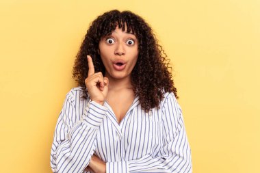 Sarı arka planda soyutlanmış genç melez bir kadının harika bir fikri var, yaratıcılık kavramı..