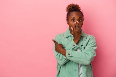 Pembe arka planda izole edilmiş genç Afrikalı Amerikalı kadın...
