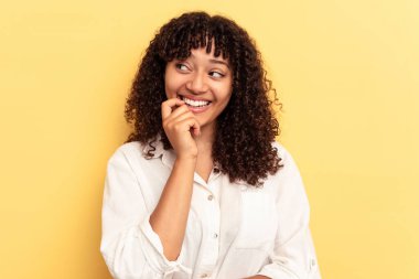 Sarı arka planda izole edilmiş genç bir ırk kadını rahat bir şekilde fotokopi odasına bakan bir şeyi düşünüyor..