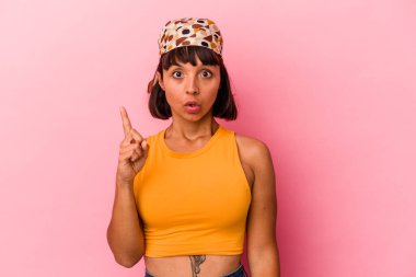 Pembe arka planda izole edilmiş, ağzı açık, üst tarafı gösteren genç melez bir kadın..