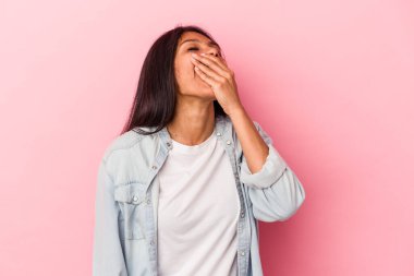 Pembe arka planda izole edilmiş genç Latin kadın güler, kaygısız, doğal duygular.