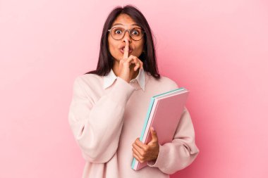 Pembe arka planda izole edilmiş genç Latin bir bayan bir sır saklıyor ya da sessizlik istiyor..