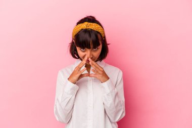 Genç melez kadın, pembe arka planda izole edilmiş bir plan yapıyor, bir fikir kuruyor..