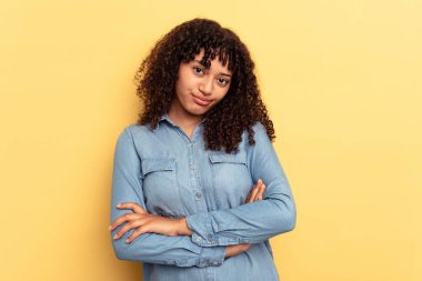 Sarı arka planda soyutlanmış, sıkılmış, yorgun ve dinlenmeye ihtiyacı olan genç melez bir kadın..