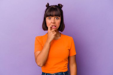 Mor arka planda izole edilmiş, tırnak yiyen, gergin ve endişeli genç bir ırk kadını..