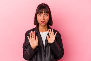 Pembe arka planda izole edilmiş genç melez bir kadın yaklaşan bir tehlike nedeniyle şok oluyor.